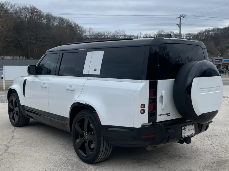 White Land Rover Defender 130 SUV rear view with spare tire and tinted glass