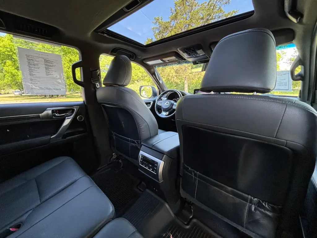 Rear passenger seating in a 2023 Lexus GX 460 with black leather upholstery and a sunroof.