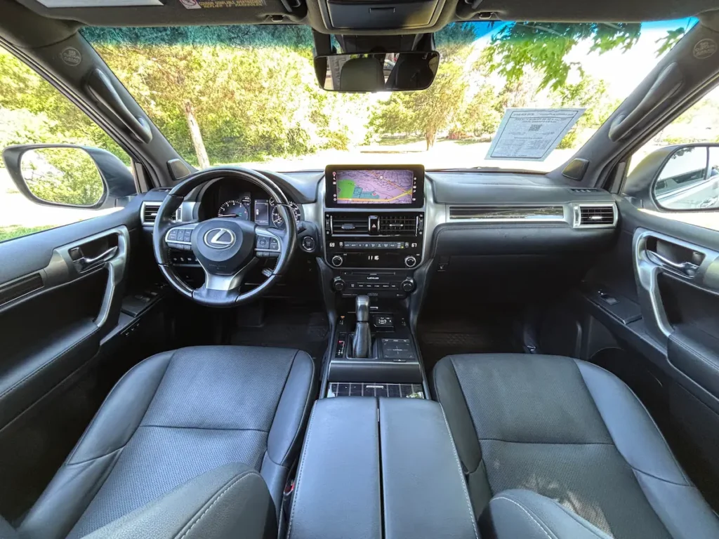 Front interior of a 2023 Lexus GX 460 with black leather seats and a navigation display.