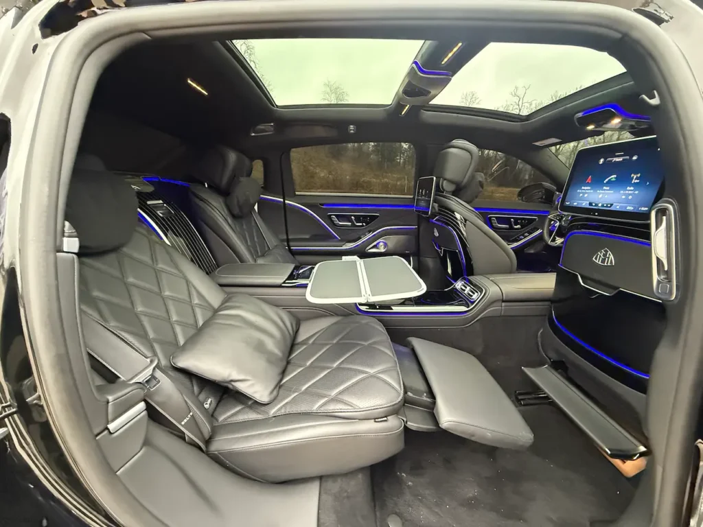 2023 Mercedes-Benz S680 Maybach rear seats with leg rests, tablet console, and panoramic sunroof.