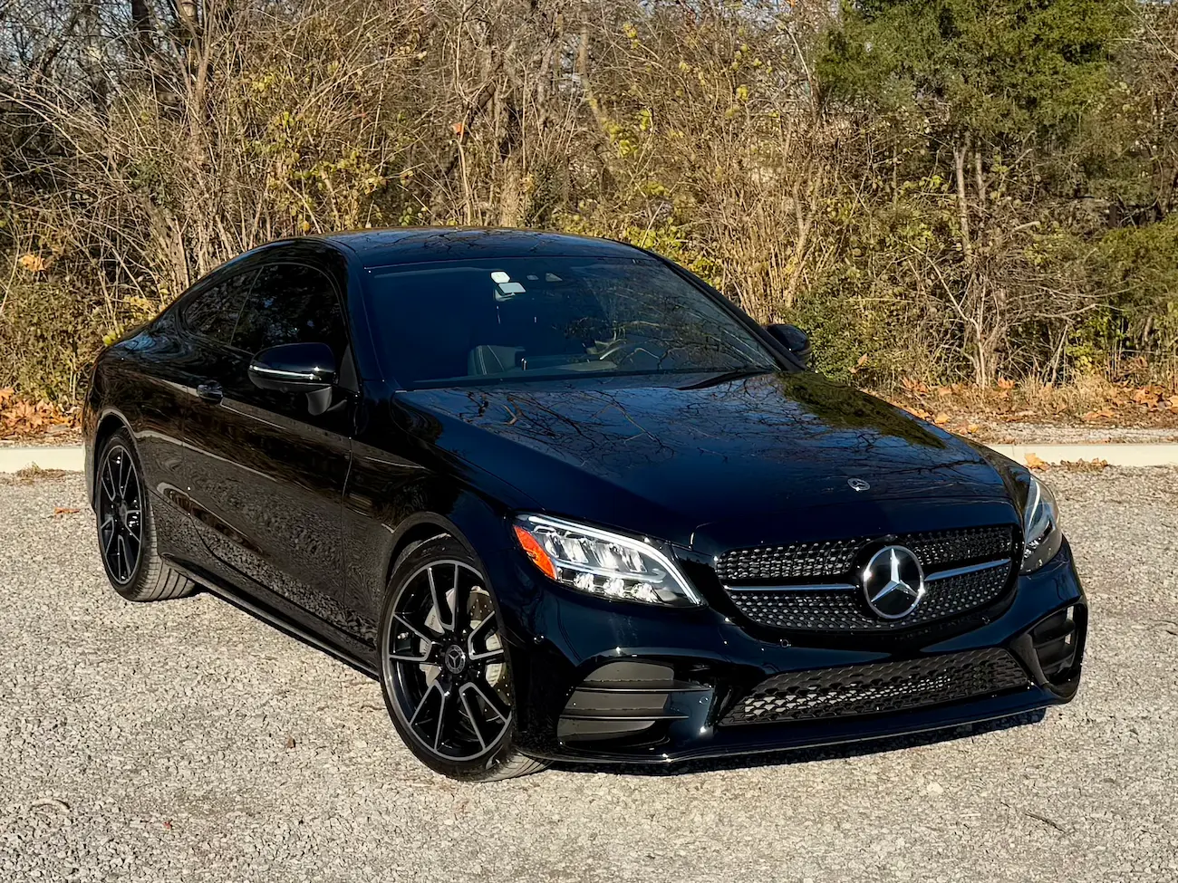 ront angle of a black 2023 Mercedes-Benz C 300 Coupe with AMG grille and sporty stylin