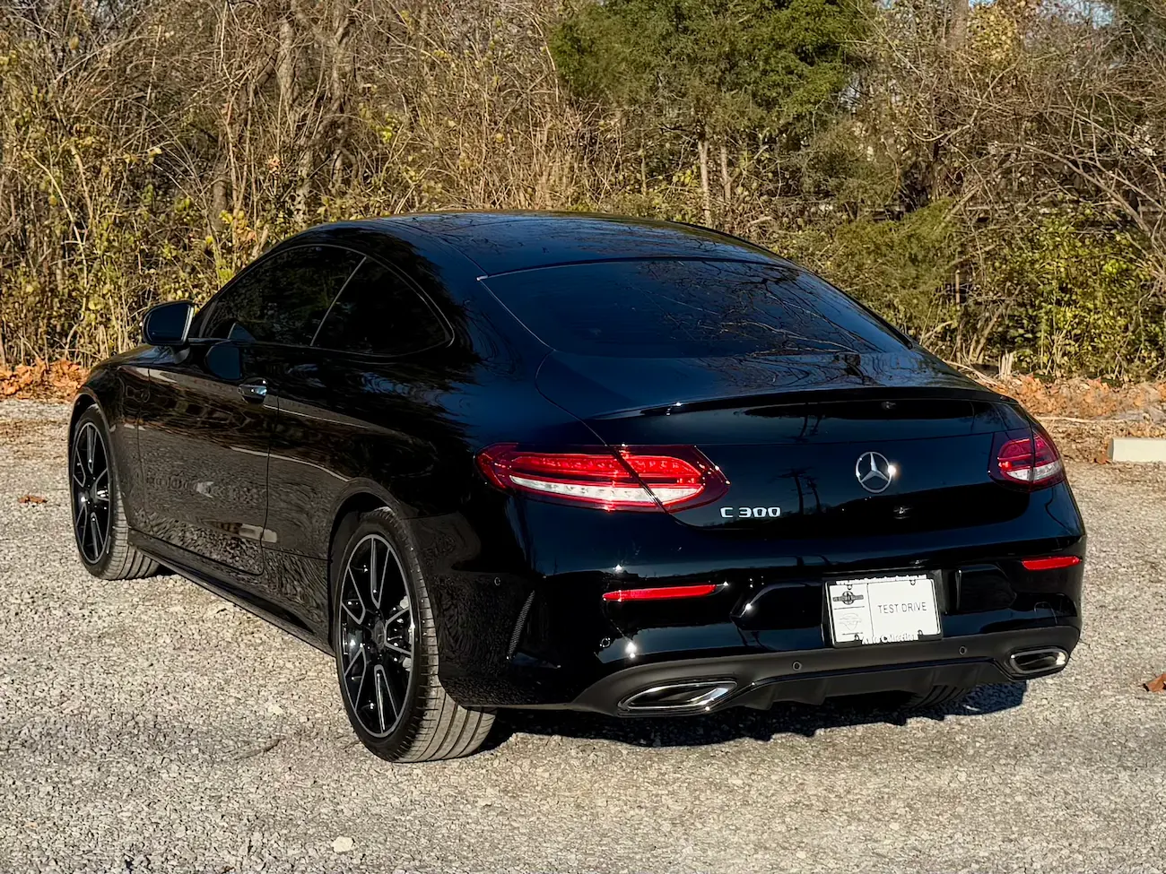 Rear view of black 2023 Mercedes-Benz C 300 Coupe showing LED taillights and dual exhaust