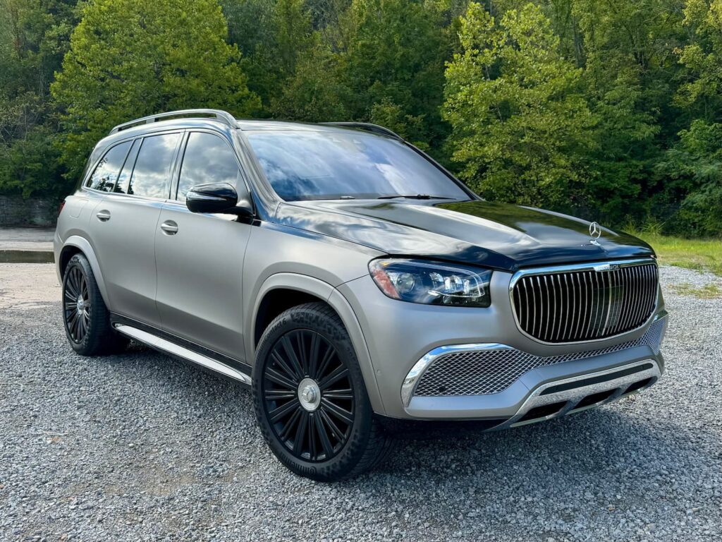 2023 Mercedes-Benz GLS 600 Maybach with a striking two-tone matte silver and black wrap, parked in a scenic outdoor location.