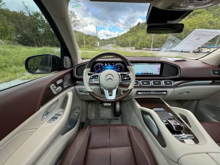 The luxurious interior of the 2023 Mercedes-Benz GLS 600 Maybach, featuring a leather-wrapped steering wheel, high-resolution digital displays, and wood-trimmed accents.