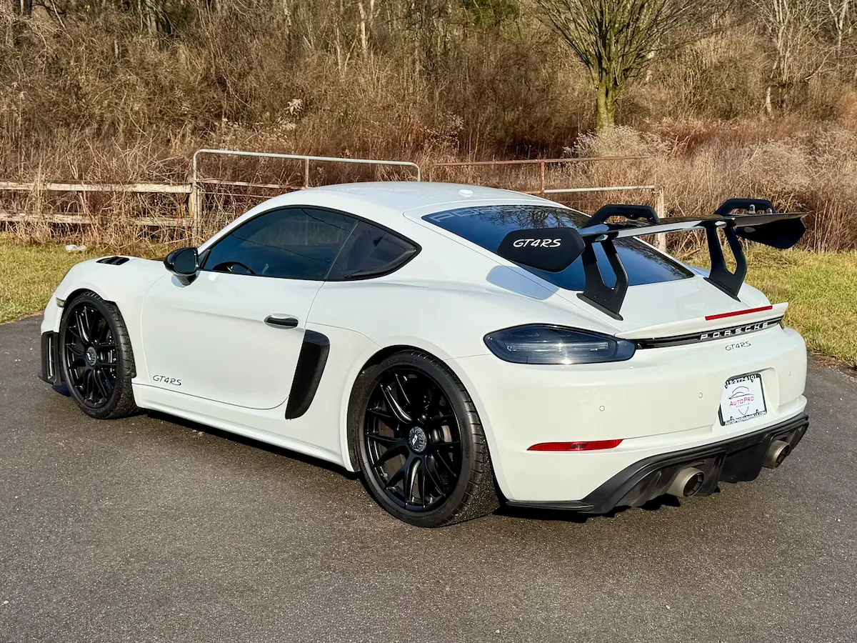 Rear view of a white 2023 Porsche 718 Cayman GT4 RS with a fixed wing