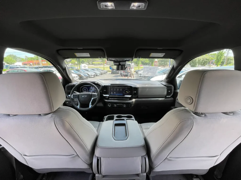 Rear cabin view of the 2023 Chevrolet Silverado 1500 RST Double Cab 4WD with premium white upholstery and spacious seating.