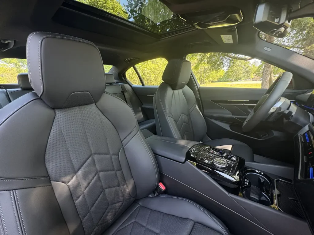 2024 BMW 530i front interior with black leather seats and crystal iDrive controller.