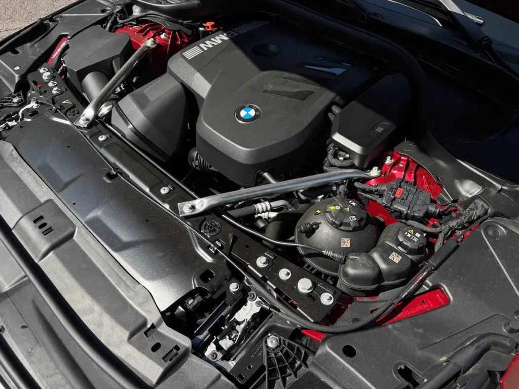 Engine bay of the 2024 BMW 530i showing the turbocharged four-cylinder with clean layout.