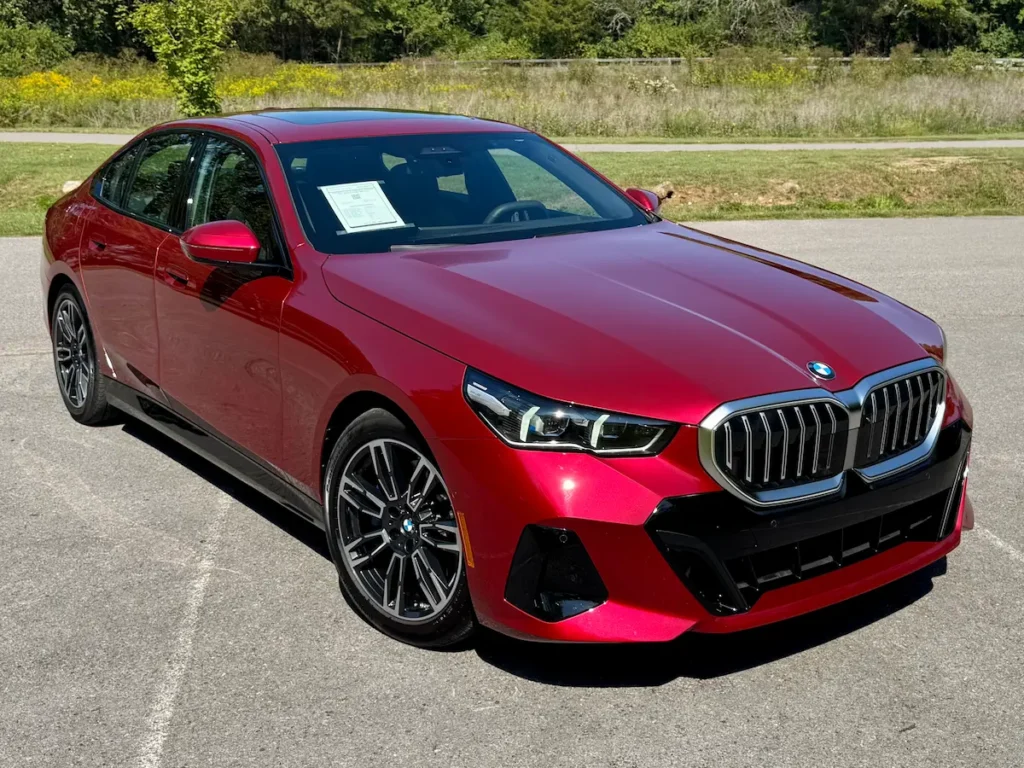 2024 BMW 530i red exterior front three-quarter view with modern LED headlights and sharp lines.