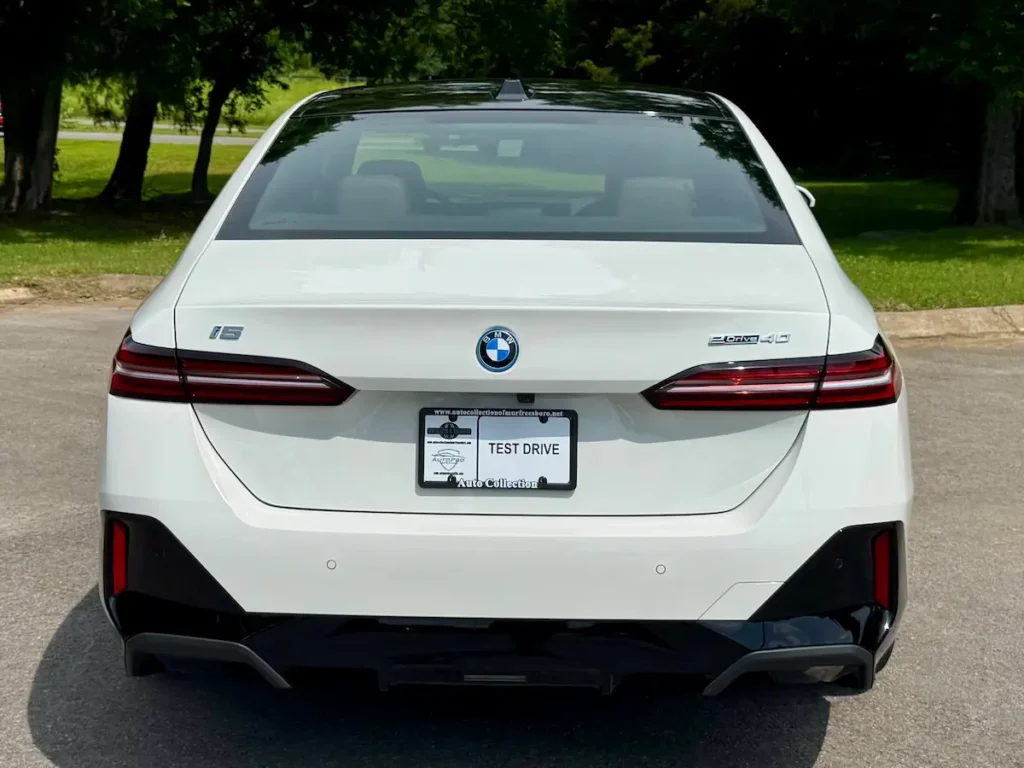 Rear view of a white 2024 BMW i5 eDrive40 showcasing its LED taillights and clean electric design.