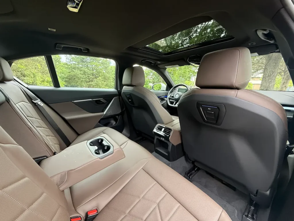 Rear seating area of the 2024 BMW i5 showing brown leather seats and generous legroom.