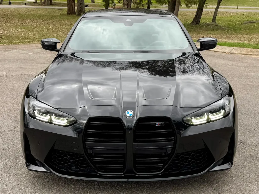 Black BMW M4 Competition front view with large kidney grille and LED headlights