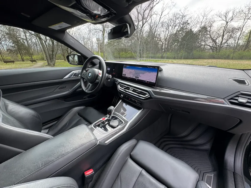 BMW M4 Competition interior with carbon fiber trim and curved digital display