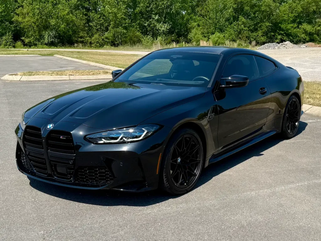 2024 BMW M4 black coupe front view with aggressive performance design