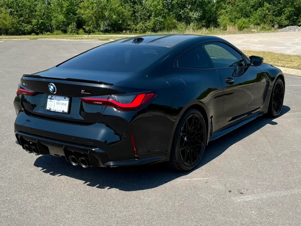 2024 BMW M4 black coupe rear view with quad exhaust tips