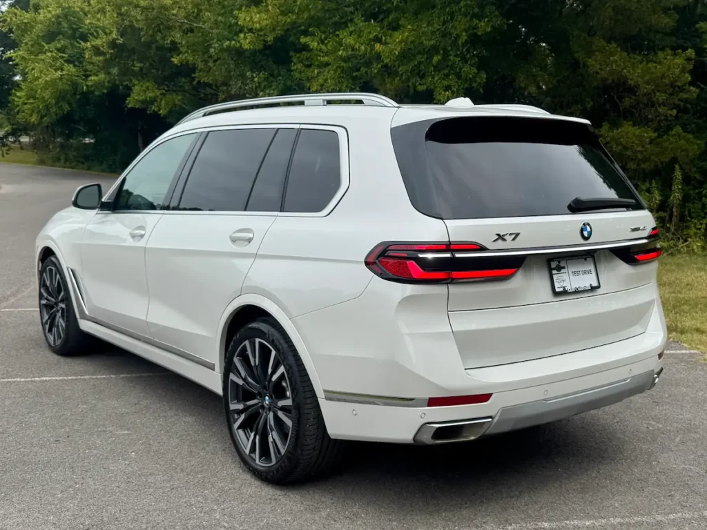 2024 BMW X7 white exterior rear three-quarter view with LED tail lights and large wheels.