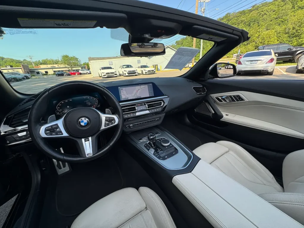 Interior of 2024 BMW Z4 black exterior, white leather seats, premium driver-focused cockpit.