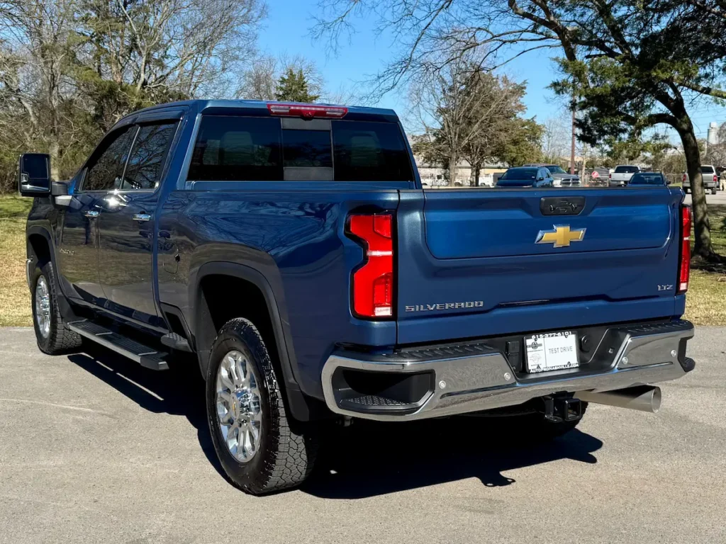 Rear three-quarter view of a blue 2024 Silverado 2500HD LTZ with chrome accents.