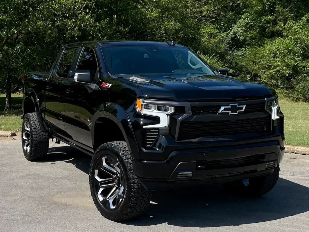 Front three-quarter view of a black 2024 Silverado 1500 RST Black Widow with off-road wheels.