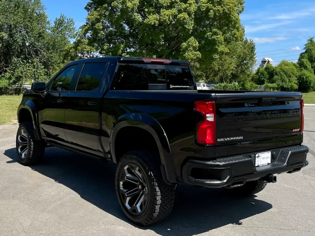 Rear three-quarter view of a lifted black 2024 Silverado 1500 RST Black Widow edition.