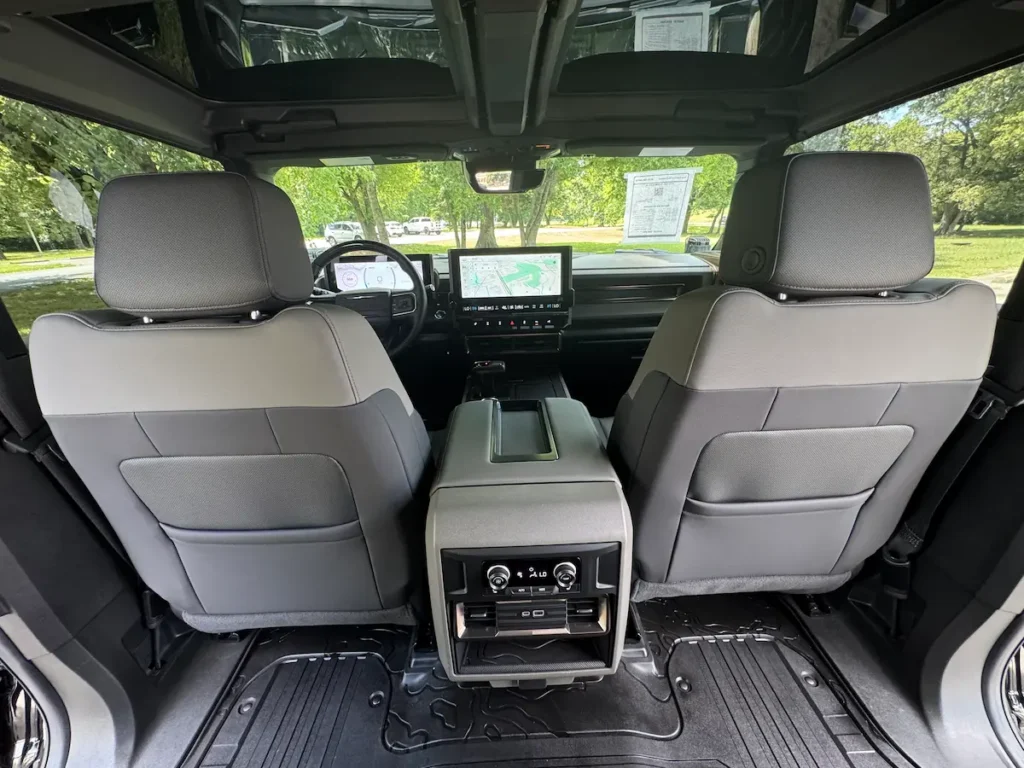 Front interior of a 2024 GMC Hummer EV with panoramic roof and digital displays.