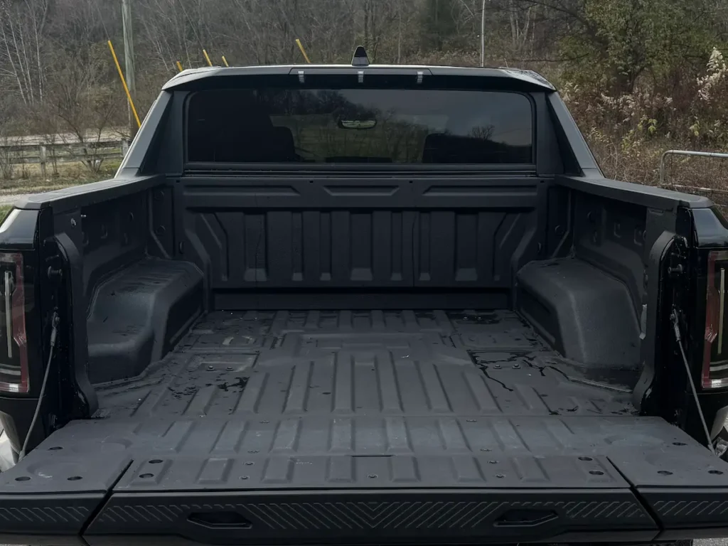 Open truck bed of a 2024 GMC Hummer EV, showing durable liner and cargo space.