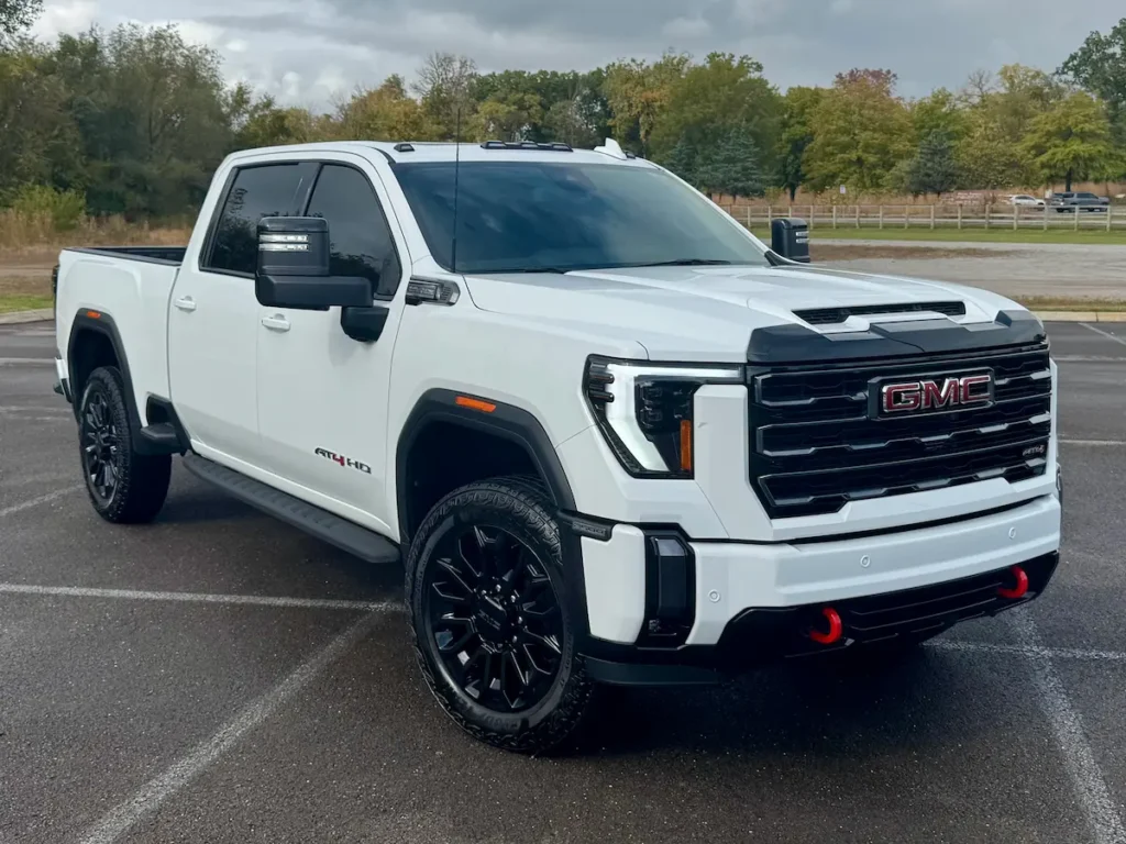 Front exterior of a white 2024 GMC Sierra 2500 AT4 HD with black wheels at AutoPro Nashville.