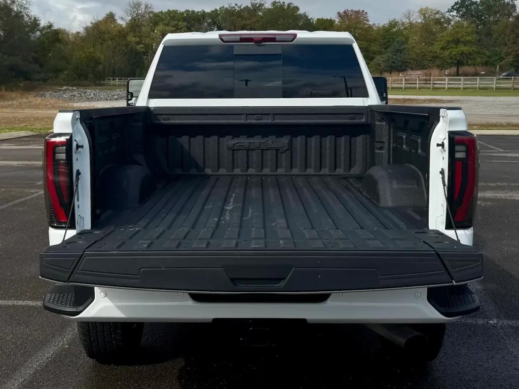 Open bed of a 2024 GMC Sierra 2500 AT4 HD with spray-in liner and MultiPro tailgate.