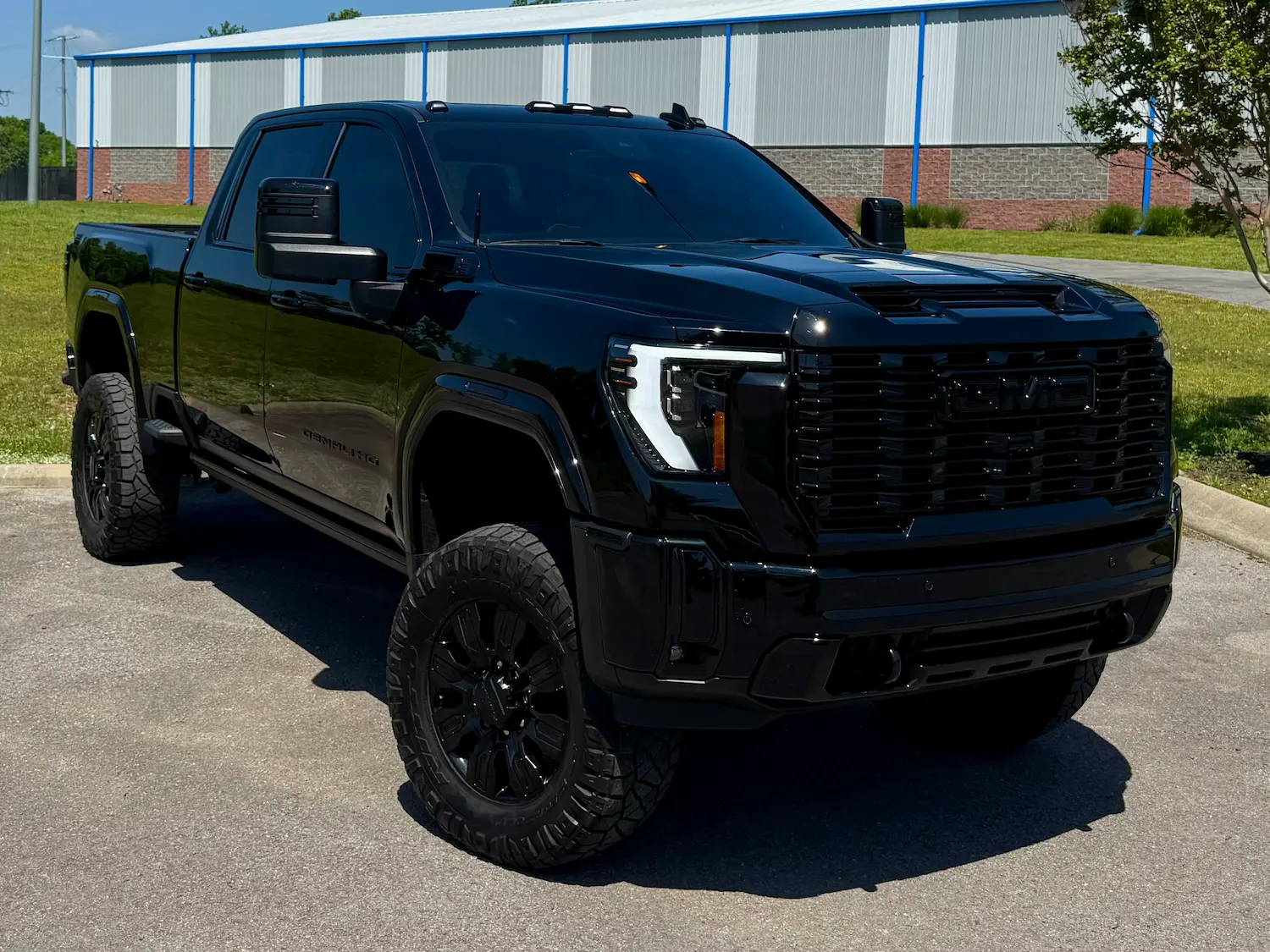 2024 GMC Sierra 2500 Denali Ultimate black exterior lifted stance and aggressive styling