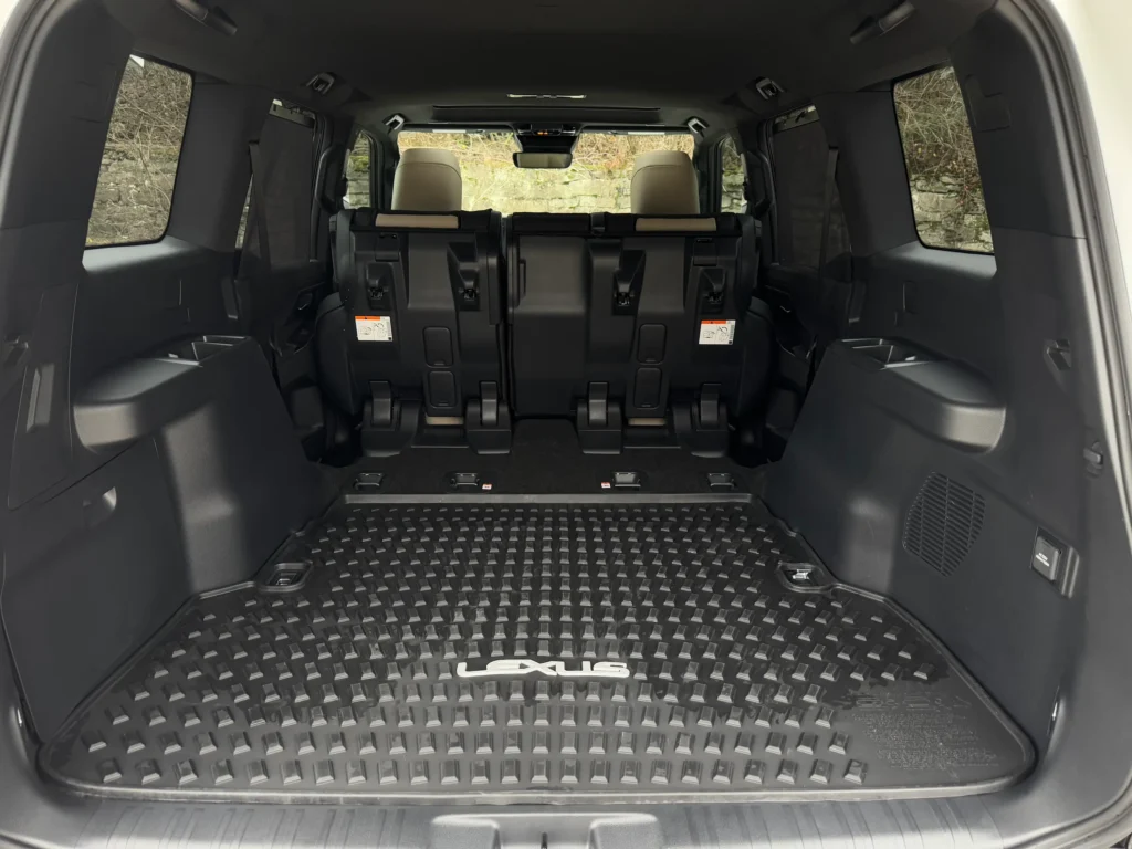 Spacious cargo area of the 2024 Lexus GX 550 with folded third-row seats and durable Lexus-branded floor mat.