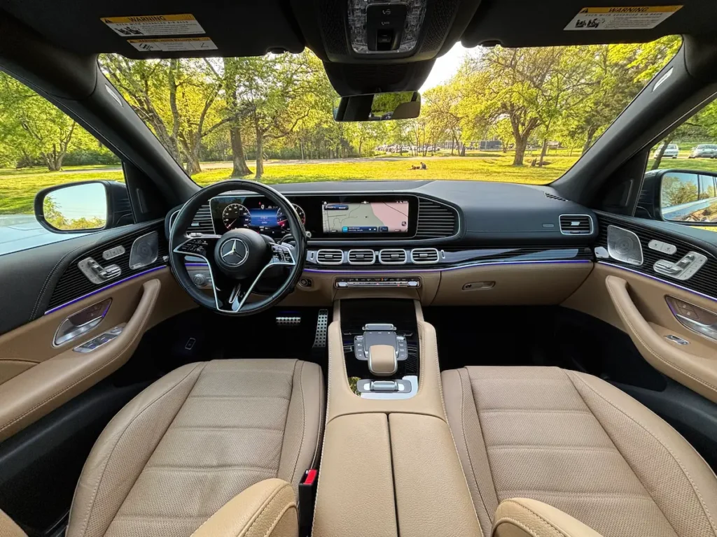 2024 Mercedes-Benz GLS 580 front interior with tan leather seats, MBUX screens, and ambient lighting