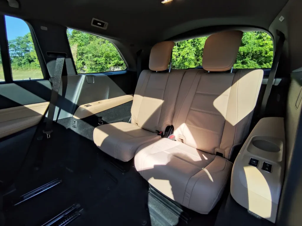 Third-row seating in 2024 Mercedes-Benz GLS 580 featuring tan leather upholstery and foldable seatbacks.