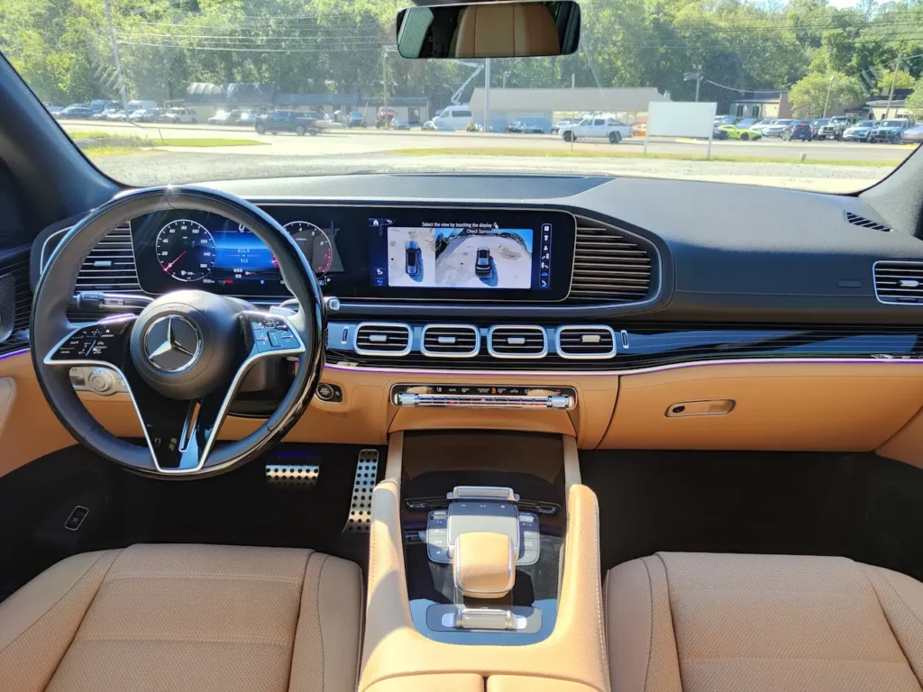 Dashboard of 2024 Mercedes-Benz GLS 580 with dual digital displays, Nappa leather, and modern wood trim.