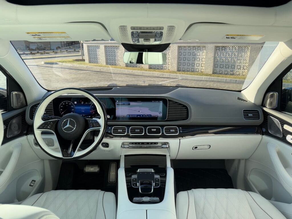 Driver's seat view of the 2024 Mercedes-Benz GLS 600 Maybach, showcasing a luxurious black and white leather interior with a digital cockpit.