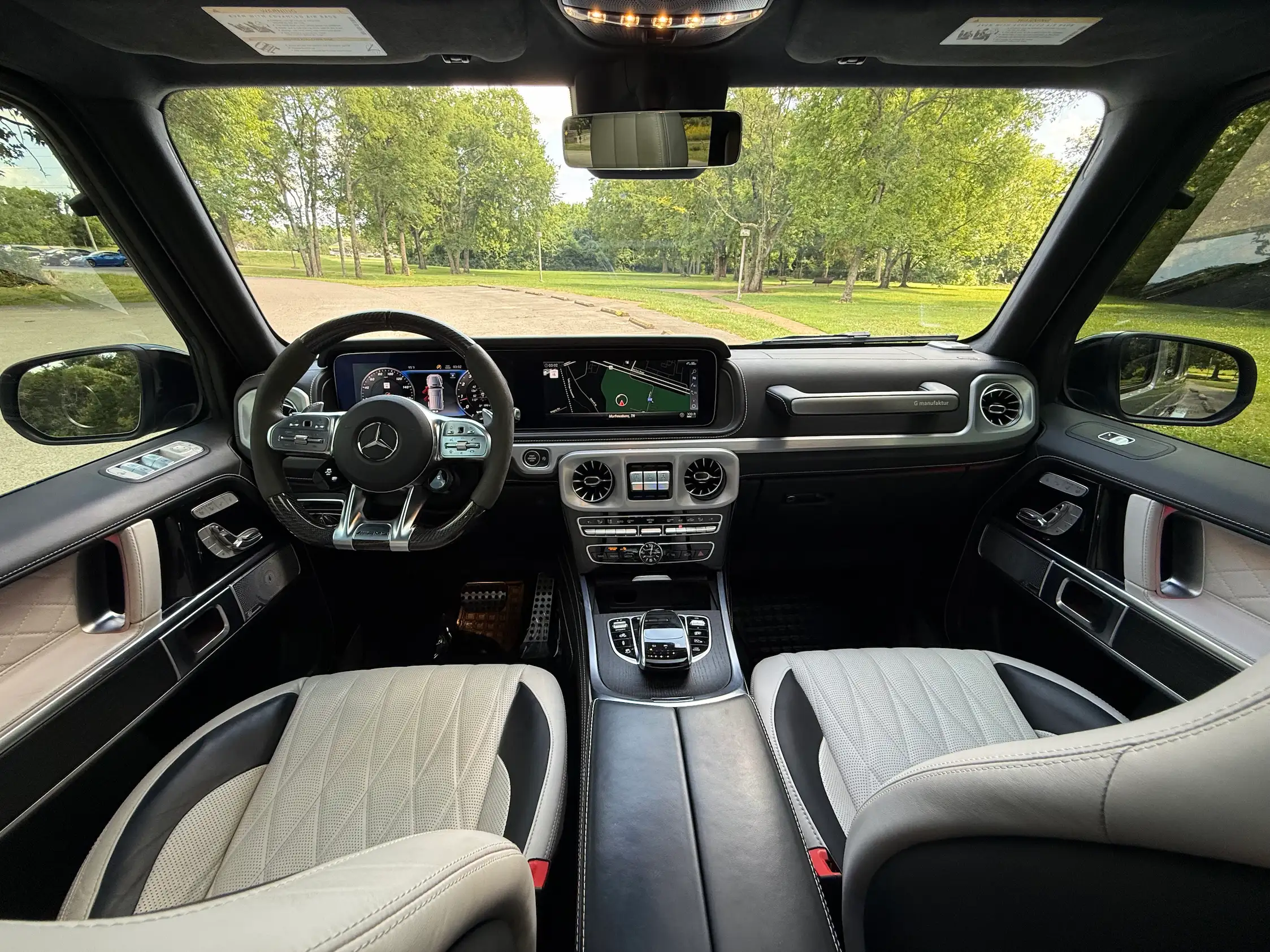 2024 Mercedes-AMG G 63 front cabin with light quilted seats, dashboard displays and circular center air vents.