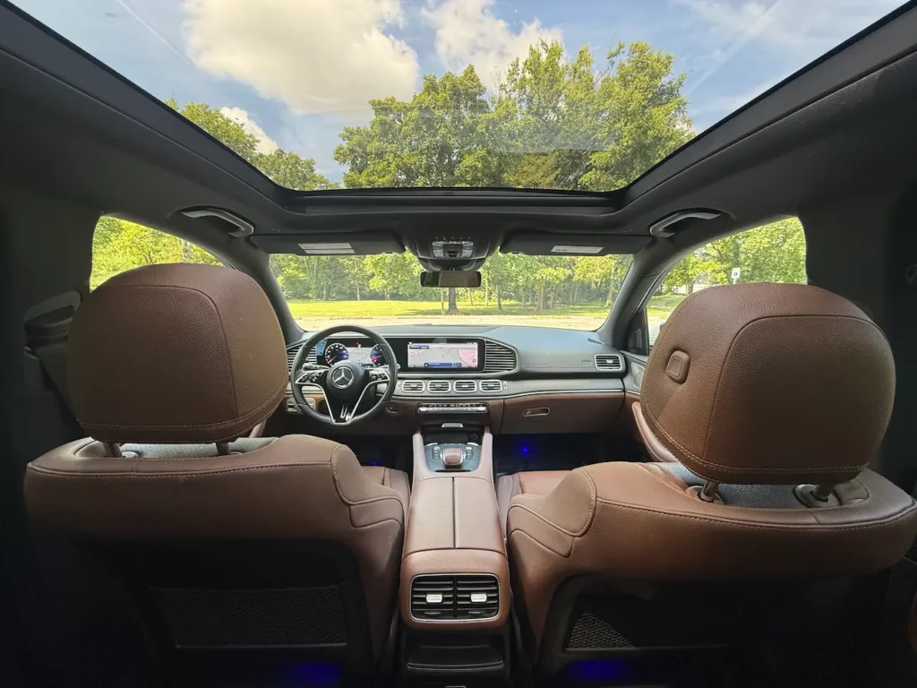 Interior of 2024 Mercedes-Benz GLE 350 showing panoramic roof and dual displays from rear seats.