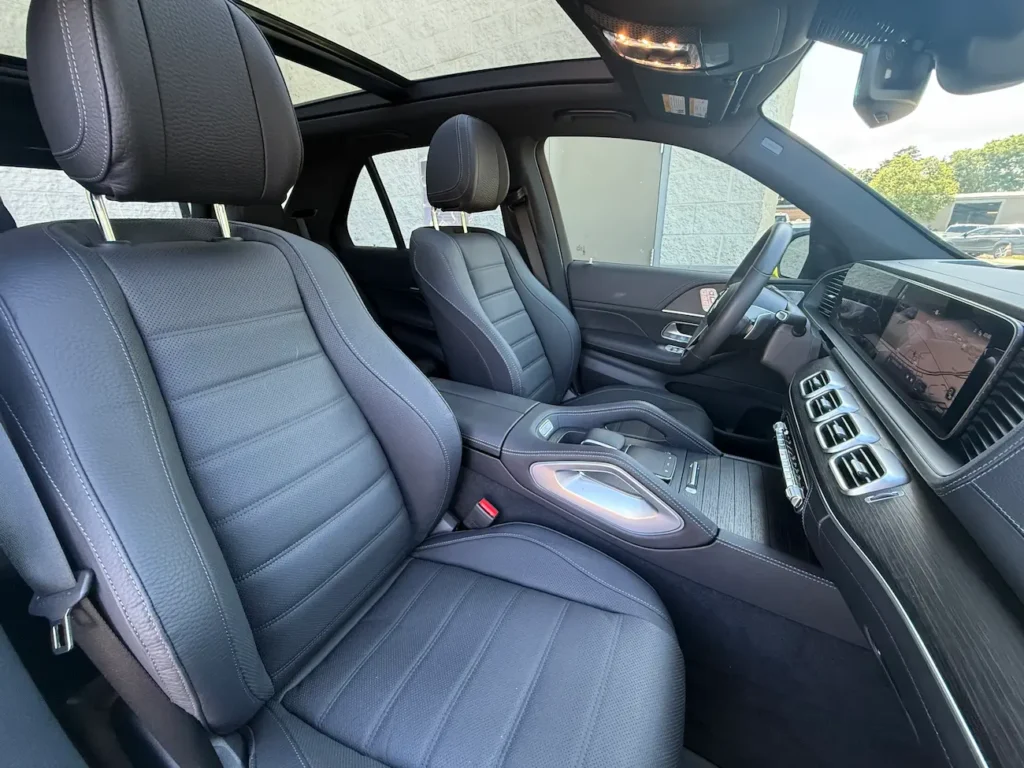 Front passenger view of 2024 Mercedes-Benz GLE 450 interior with luxury materials and ambient lighting.