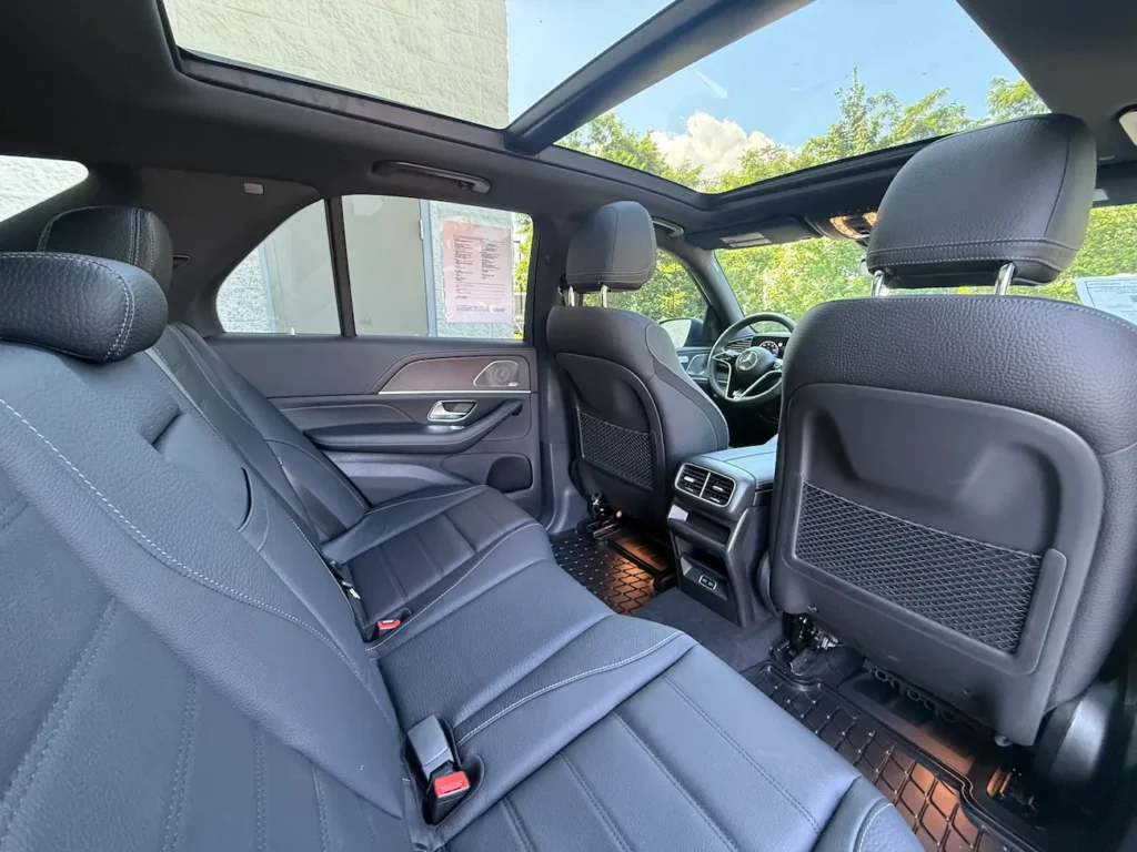 Rear seats of 2024 Mercedes-Benz GLE 450 with black leather and panoramic sunroof.