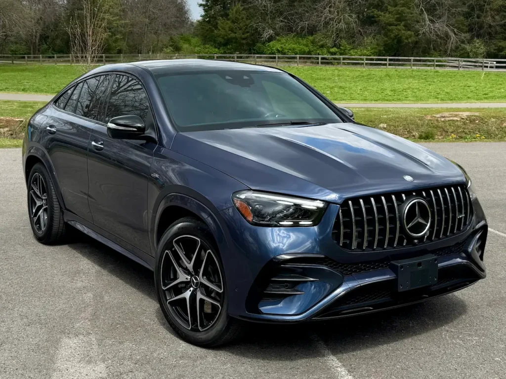2024 Mercedes-Benz GLE 53 AMG Coupe front angle view in blue with AMG grille and LED headlights.