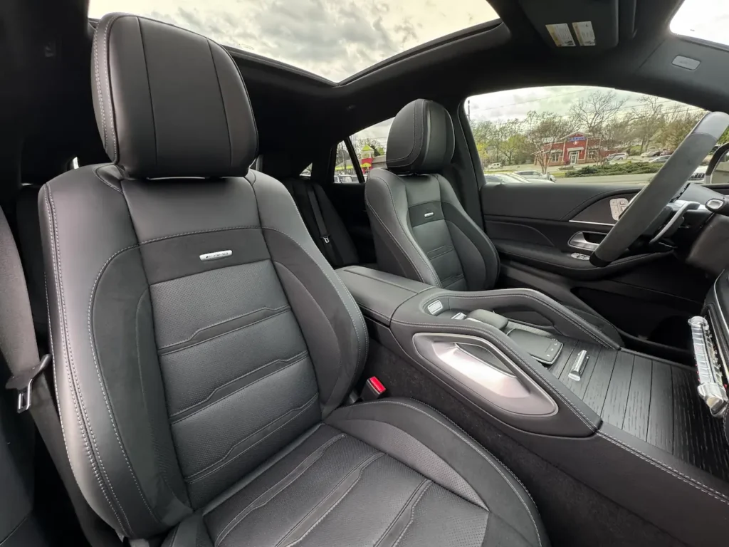 Front seats of 2024 Mercedes-Benz GLE 53 AMG Coupe in black leather with AMG badging and detailed stitching.