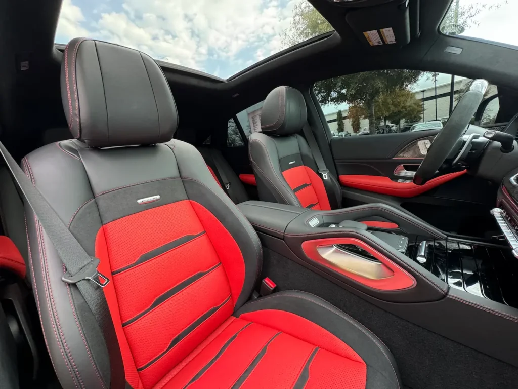 Front sport seats of 2024 Mercedes-Benz GLE 63 S AMG Coupe in red and black leather with AMG badging.