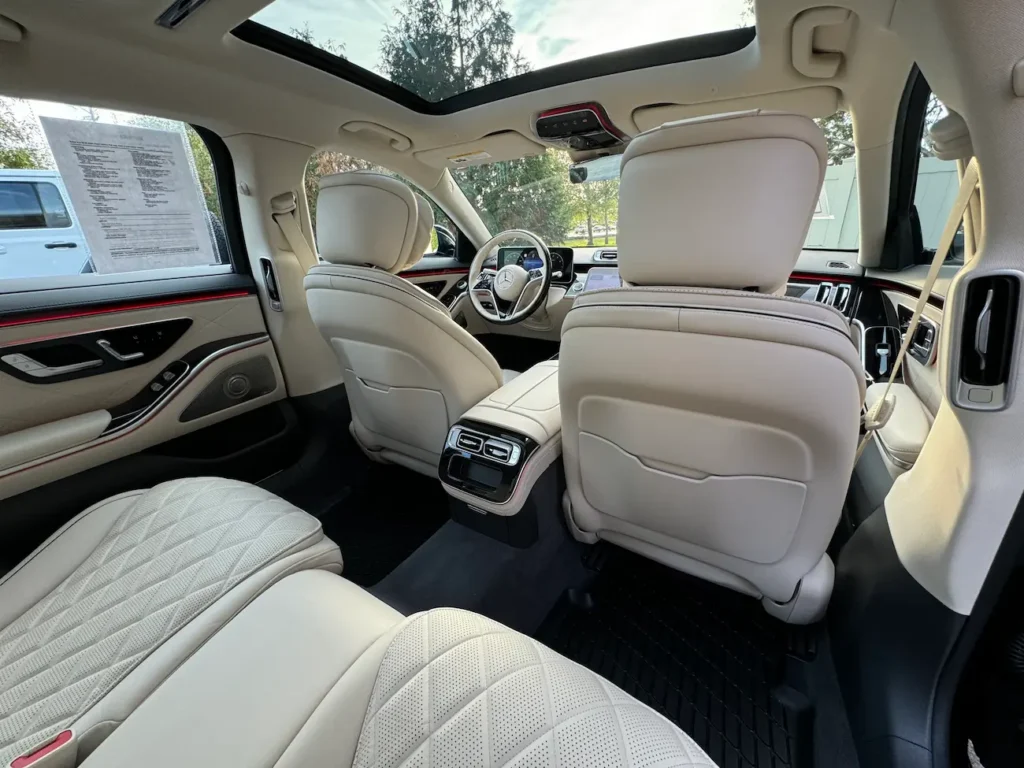 Rear cabin of the 2024 Mercedes-Benz S580 showing spacious legroom, soft-touch materials, and ambient lighting.