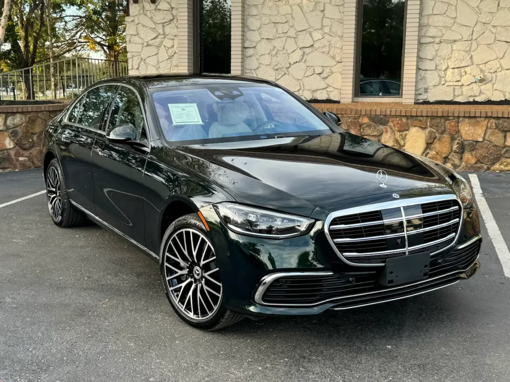 Front view of the 2024 Mercedes-Benz S580 in emerald green showcasing elegant grille and LED headlights.