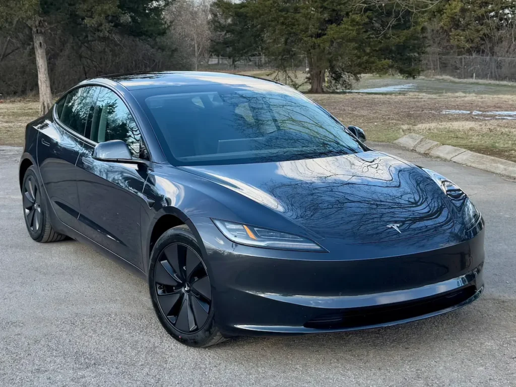 2024 Tesla Model 3 Long Range in gray, front three-quarter view showing updated headlights and aerodynamic body.