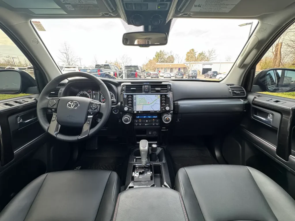 Front interior of a 2024 Toyota 4Runner with black seats, navigation screen, and center controls.