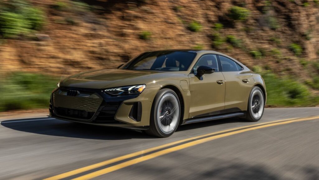 A green 2023 Audi RS e-tron GT driving on a winding coastal road