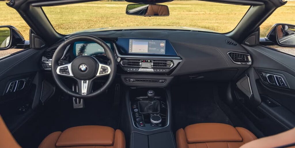 Dashboard and interior of 2024 BMW Z4 M40i with brown leather seats, digital cluster, and manual gear shifter.