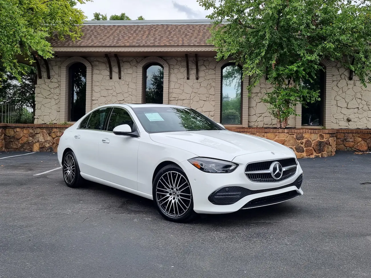 Front view of a white 2024 Mercedes-Benz C 300 Sedan showcasing new grille design and sleek LED headlights.
