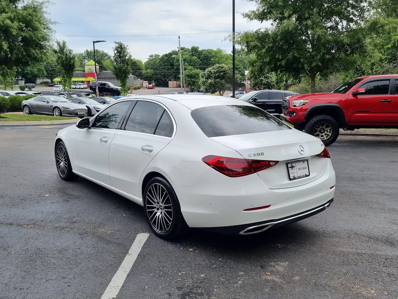 Rear view of a white 2024 Mercedes-Benz C 300 Sedan with chrome accents and new taillight design.