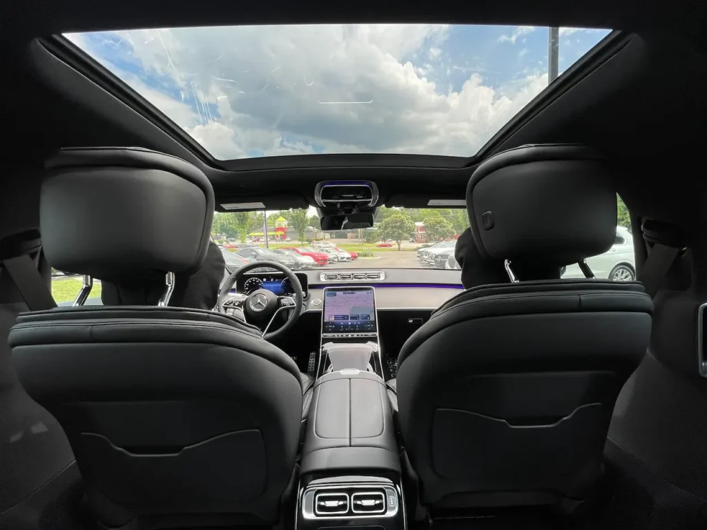 Rear seating area of the 2024 Mercedes-Benz S580e showcasing spacious legroom and high-end finishes.